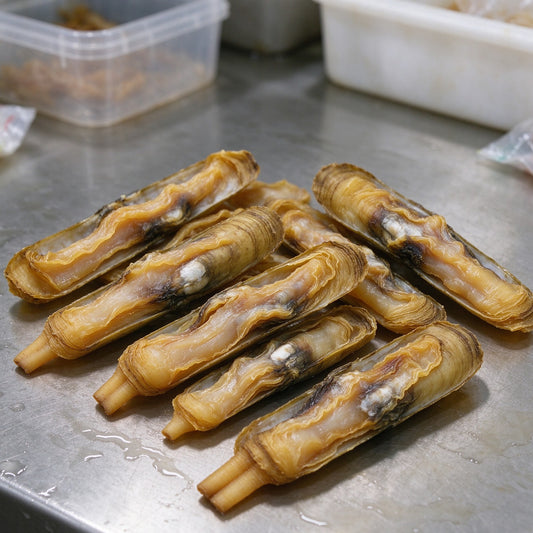Bamboo clams with ridged olive shells on a metal tray