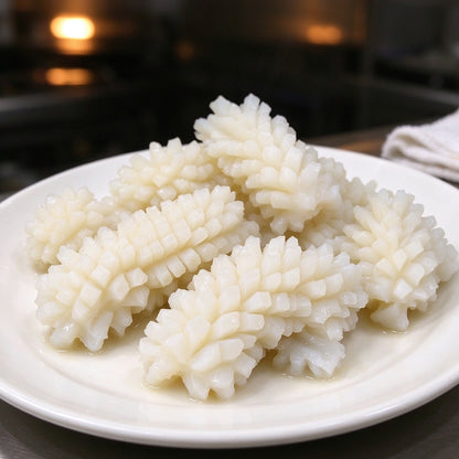 Scored squid pieces with a cross-hatch pattern on a plate