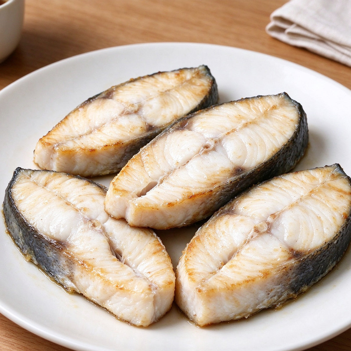 Thick halibut steaks with dark skin on a steel tray