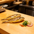 Whole yellow croakers with golden skin on a wooden board