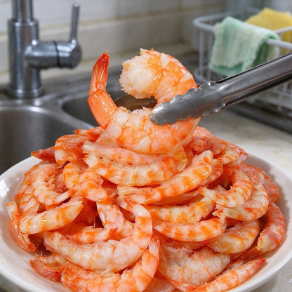 Pile of cooked orange shrimp on a white plate